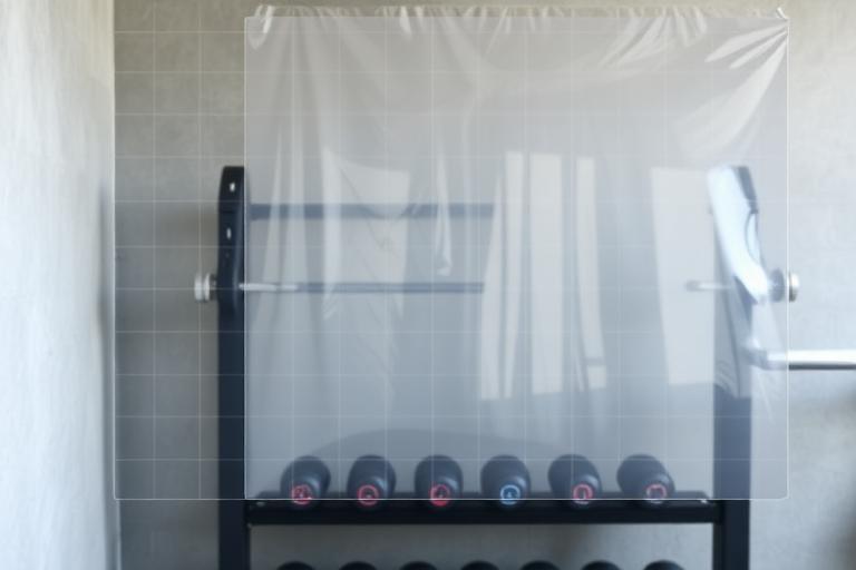 Transparent DayByLife wall planner used as a year-long workout plan — the clear grid shows the wall behind it